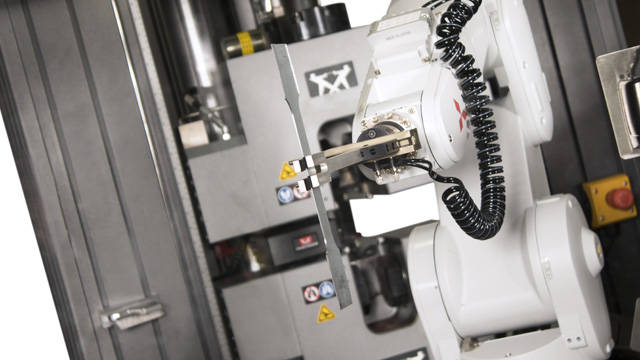 Robot Mitsubishi tenant un échantillon de métal