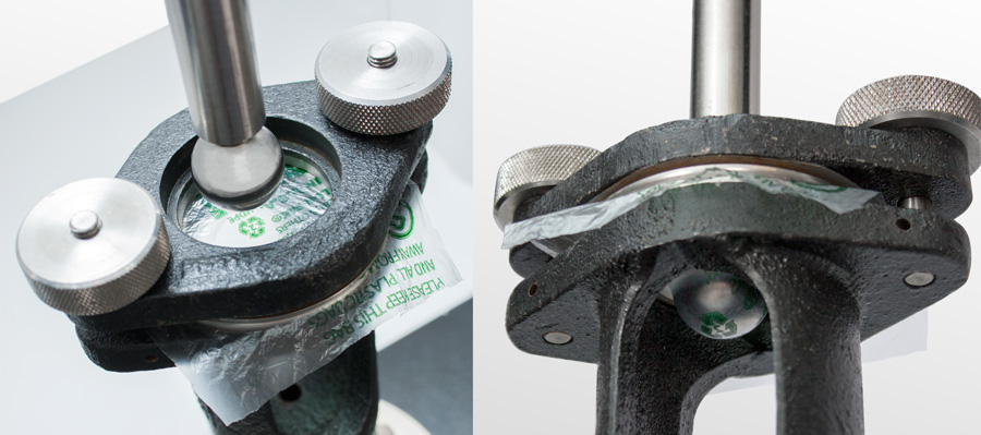 | Instron Close-up of a steel probe puncturing a recycled plastic film specimen clamped in a circular film fixture on an Instron universal testing machine during a puncture resistance test