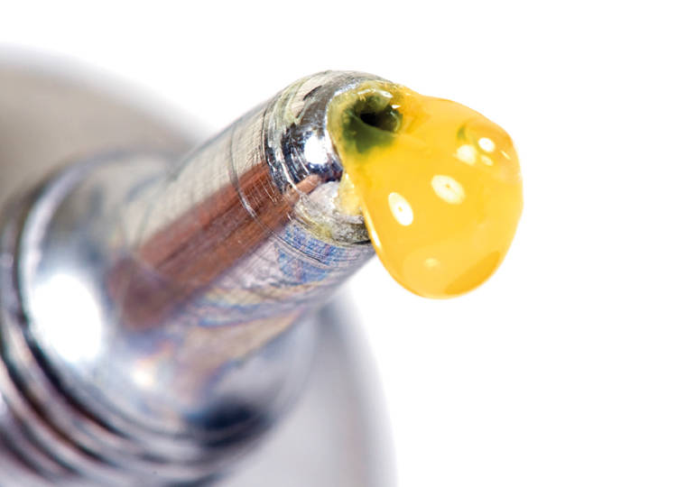 | Instron Automotive adhesive coming out of a silver tube.