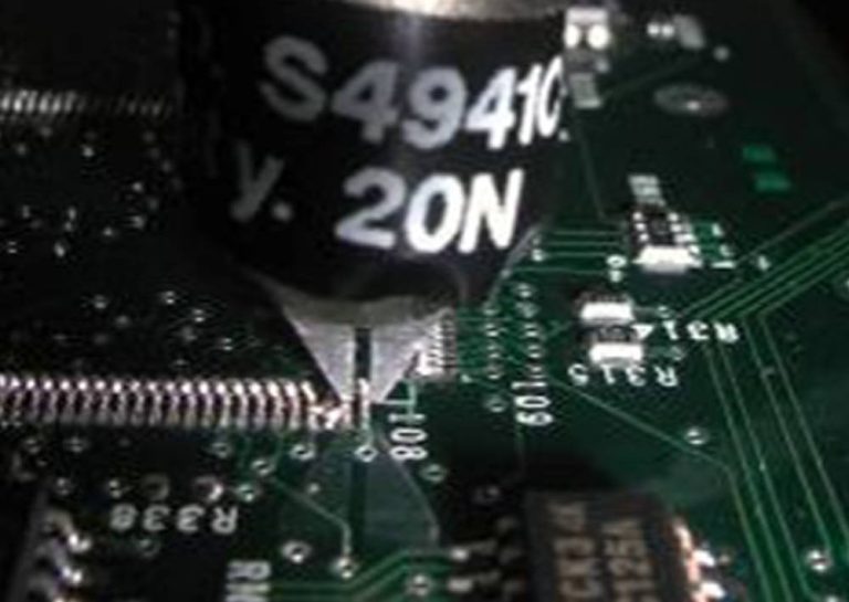 | Instron Close-up of a micro grip pulling a lead frame wire bond from a printed circuit board during tensile pull testing