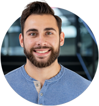 | Instron Smiling man with dark hair and a beard in a gray polo shirt against a light background (head-and-shoulders portrait).