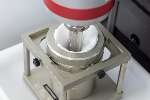 | Instron Compression test fixture on an Instron system testing a cosmetic cream sample