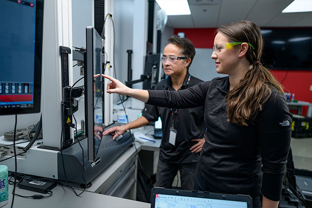 Instron instructor and student reviewing results on a testing system monitor in the Norwood training facility
