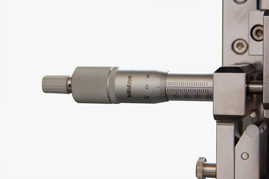 | Instron Close-up of a micrometer mounted on an Instron interlaminar shear strength test fixture, used for precise support span adjustment