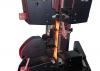 Instron testing system with grips performing tensile testing of a copper clad laminate strip specimen under red illumination