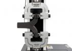 A foam specimen clamped in a pair of Instron screw side-action tensile grips on a universal testing machine performing an ISO 8067 tear strength test of flexible cellular polymeric material