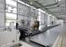 Instron Hydropuls CSAadvanced crash simulation sled system in a large automotive test facility with operators positioning a human occupant surrogate on the sled